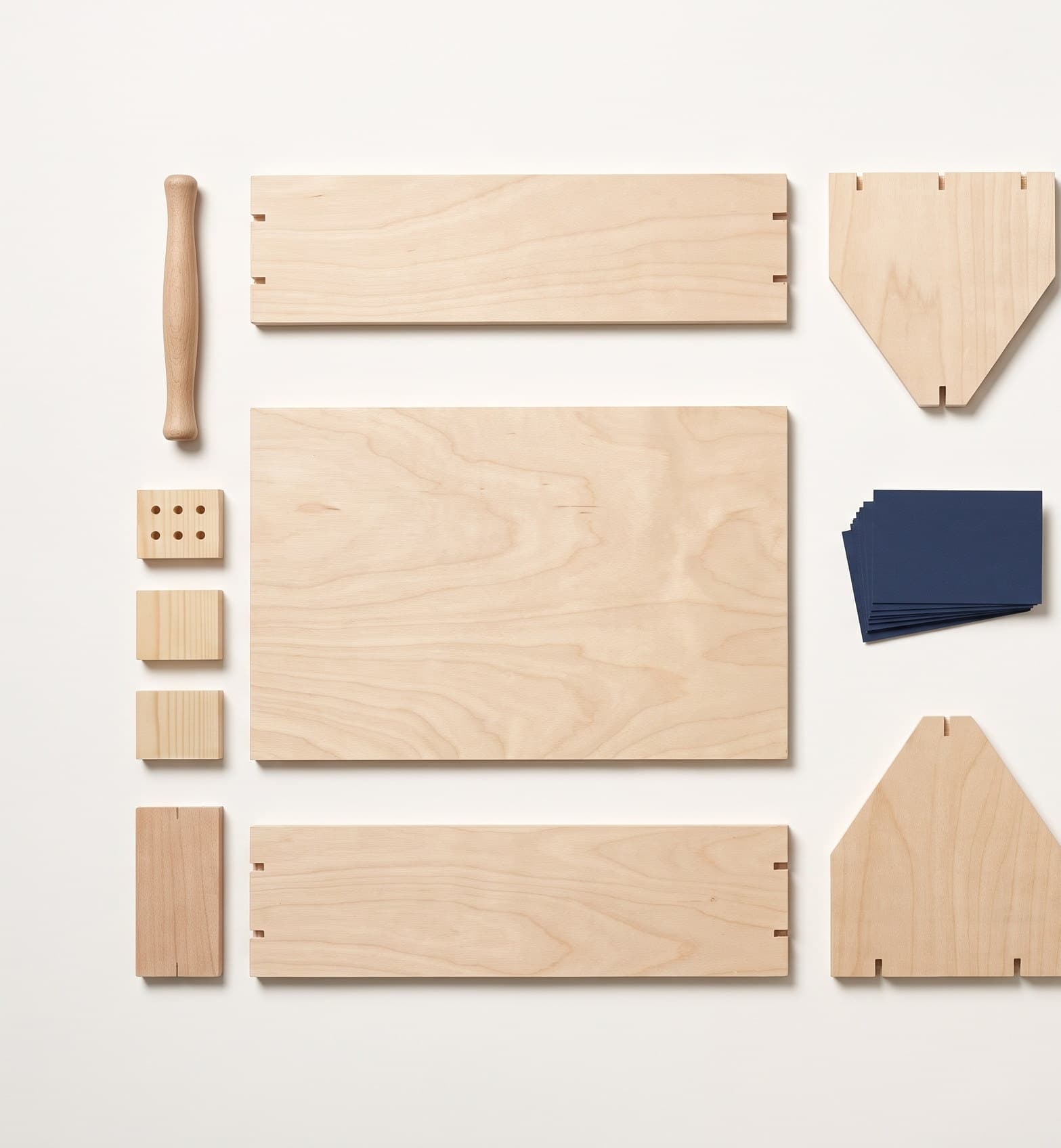 The toolbox in pieces: five plywood panels, four pine cleats, a dowel handle, a drilled warm-up offcut and a stack of navy challenge cards.